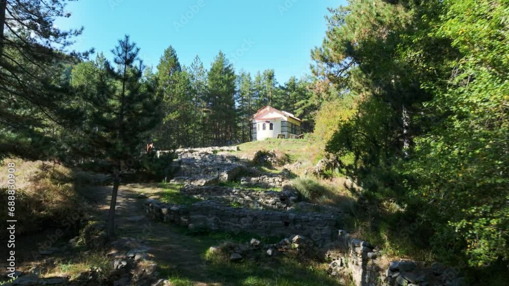 Flying through ancient Thracian ruins towards St. Nikola church on a hill in Pirin Mountains, Bulgaria. Flying through ancient Thracian ruins towards St. Nikola church on a hill in Pirin Mountains, Bulgaria.
