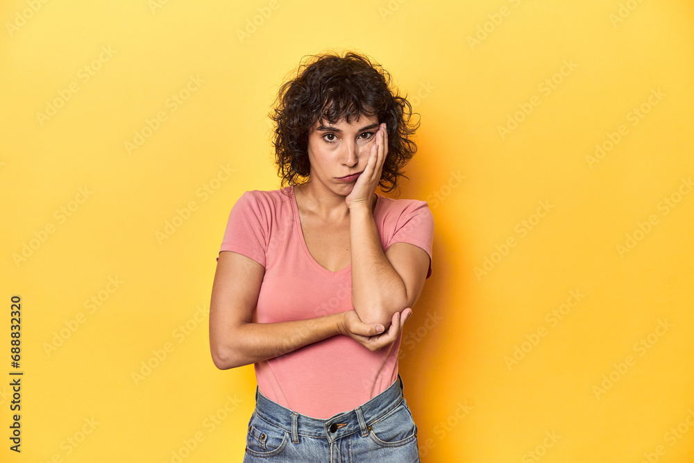 Curly-haired Caucasian woman in pink t-shirt who is bored, fatigued and need a relax day. Curly-haired Caucasian woman in pink t-shirt who is bored, fatigued and need a relax day.