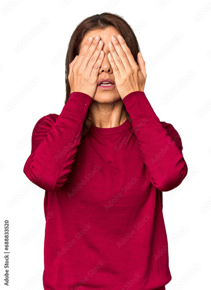 Elegant middle-aged Caucasian woman in studio setting afraid covering eyes with hands. Elegant middle-aged Caucasian woman in studio setting afraid covering eyes with hands.