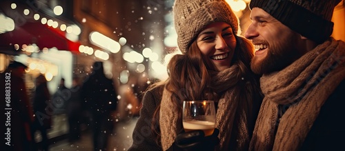 Joyful young couple in cozy attire enjoying outdoor festivities, toasting and commemorating the new year.