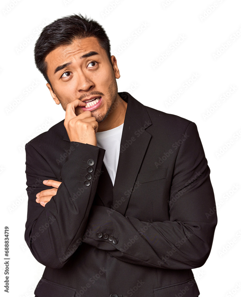 Young Chinese man in business suit in studio relaxed thinking about something looking at a copy space. Young Chinese man in business suit in studio relaxed thinking about something looking at a copy space.