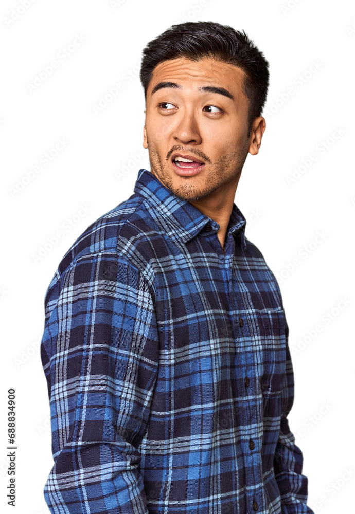Young Chinese man in studio background looks aside smiling, cheerful and pleasant. Young Chinese man in studio background looks aside smiling, cheerful and pleasant.