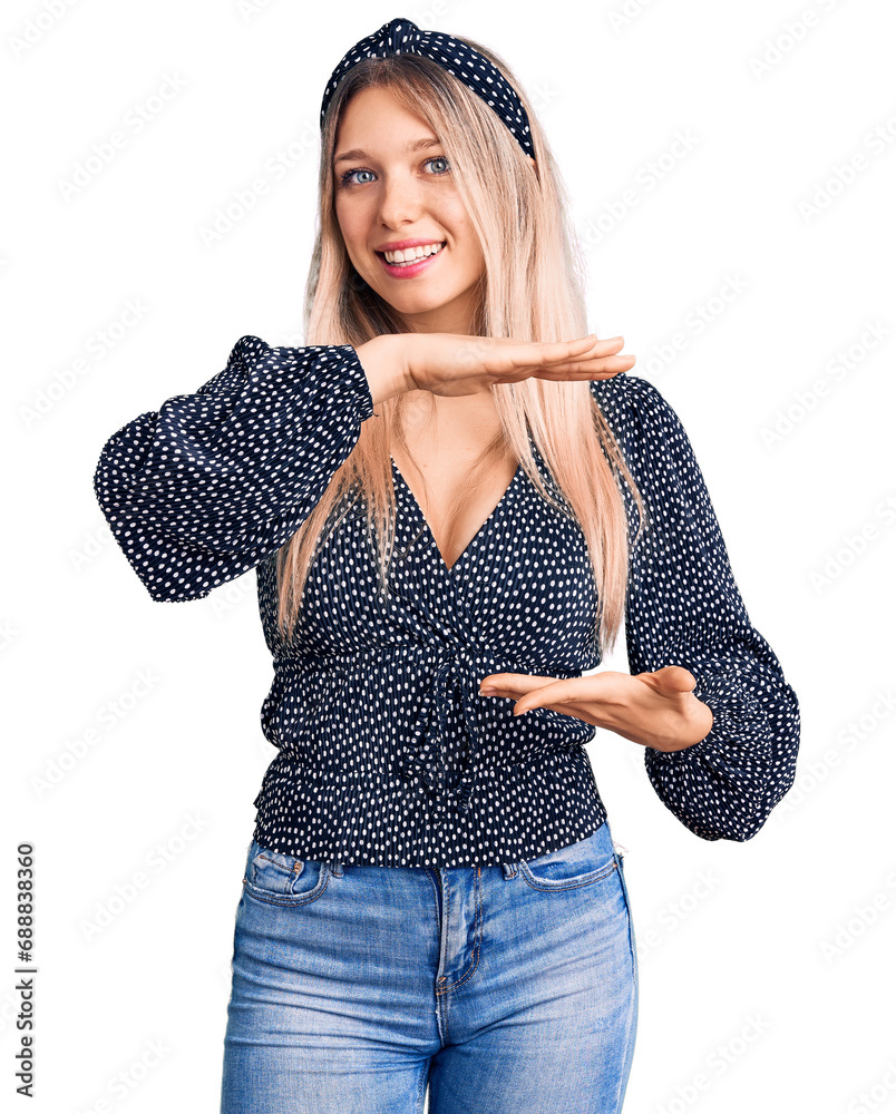Φωτογραφία Young beautiful blonde woman wearing casual clothes gesturing with hands showing big and large size sign, measure symbol