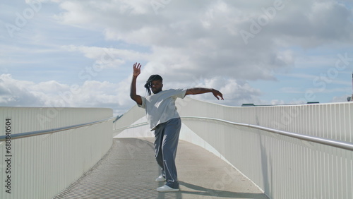 Contemporary man moving city bridge. Modern ballet dancer training outdoor alone