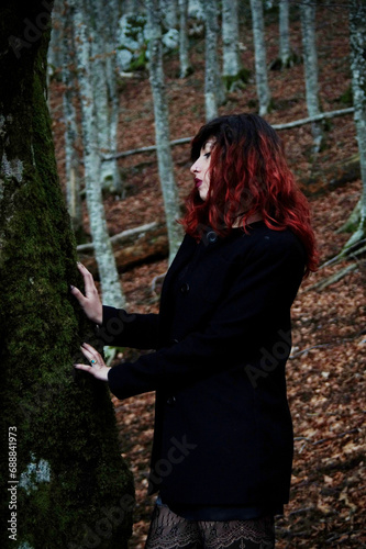 Mysterious woman amid trees, silhouette contrasting with filtered light, dark attire harmonizing with nature, creating an ethereal atmosphere.