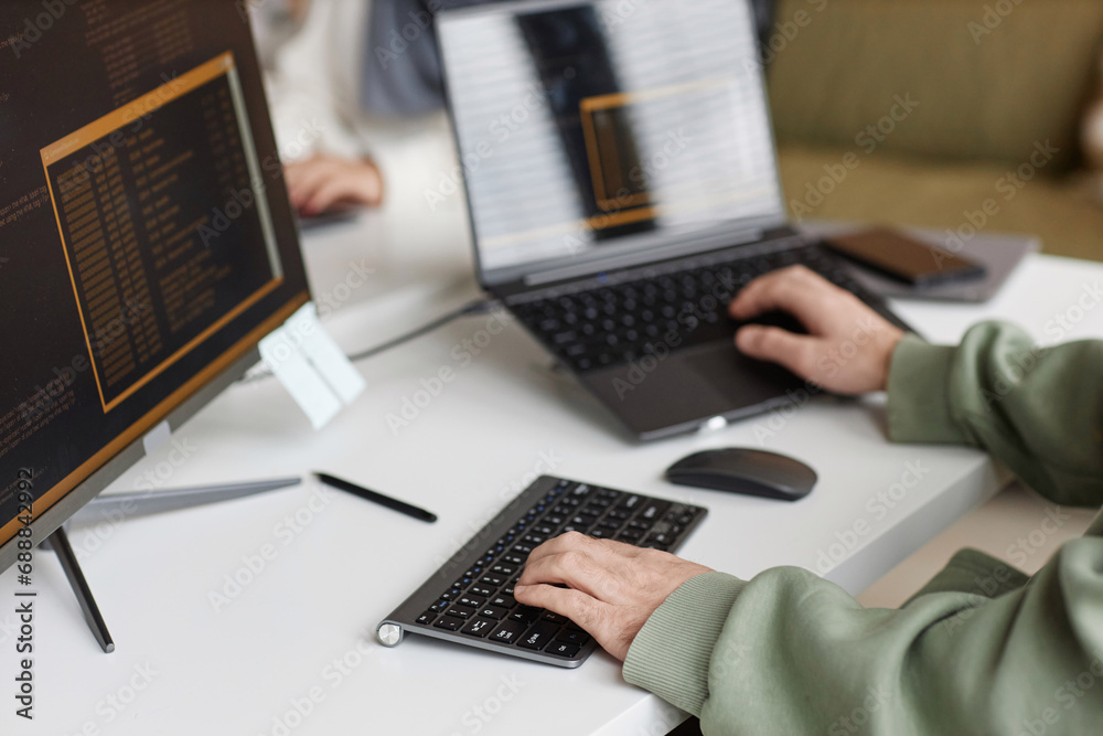 Closeup of male hands typing at computer keyboard with unrecognizable software programmer writing code, copy space Closeup of male hands typing at computer keyboard with unrecognizable software programmer writing code, copy space