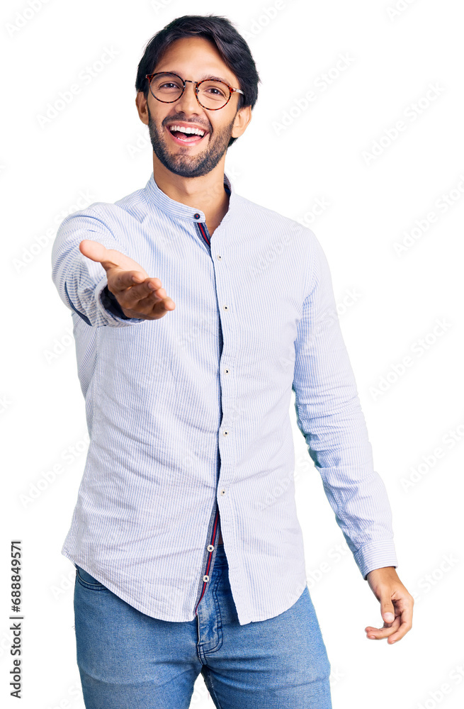 Handsome hispanic man wearing business shirt and glasses smiling friendly offering handshake as greeting and welcoming. successful business. Handsome hispanic man wearing business shirt and glasses smiling friendly offering handshake as greeting and welcoming. successful business.