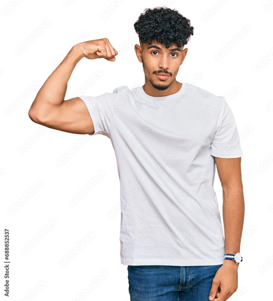 Young arab man wearing casual white t shirt strong person showing arm muscle, confident and proud of power Young arab man wearing casual white t shirt strong person showing arm muscle, confident and proud of power