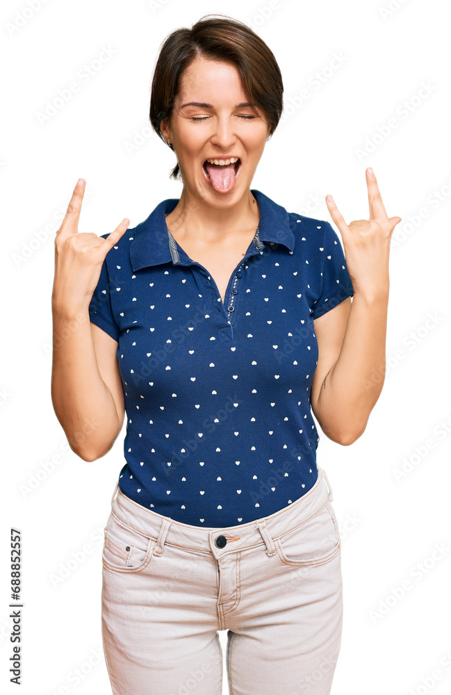 Young brunette woman with short hair wearing casual clothes shouting with crazy expression doing rock symbol with hands up. music star. heavy concept. Young brunette woman with short hair wearing casual clothes shouting with crazy expression doing rock symbol with hands up. music star. heavy concept.