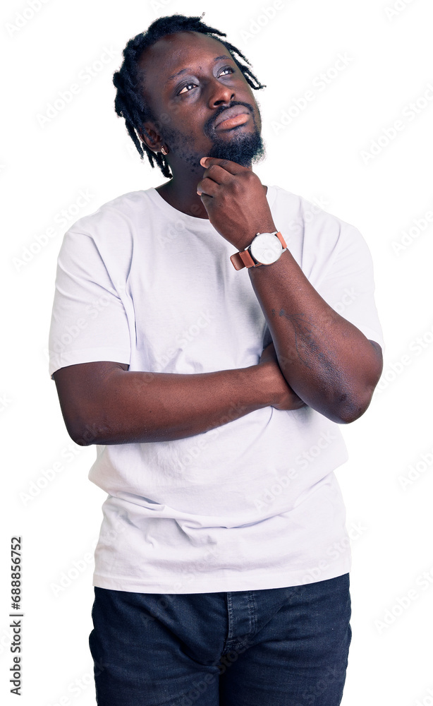 Young african american man with braids wearing casual white tshirt with hand on chin thinking about question, pensive expression. smiling with thoughtful face. doubt concept. Young african american man with braids wearing casual white tshirt with hand on chin thinking about question, pensive expression. smiling with thoughtful face. doubt concept.