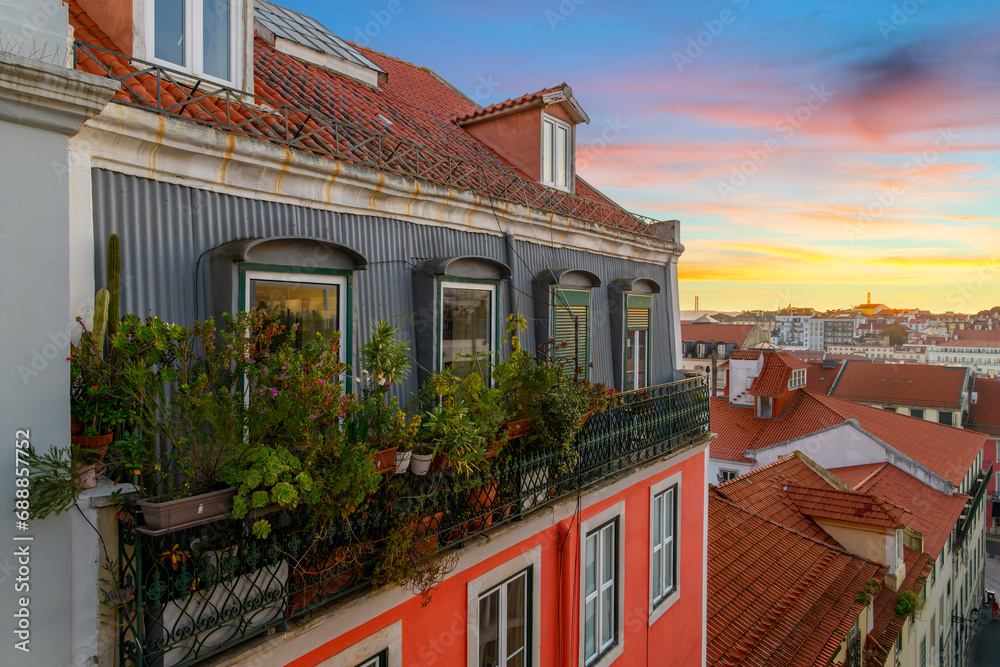 Obraz na płótnie View from an alley with colorful residential buildings and terraces in the Alfama district overlooking the city of Lisbon Portugal at sunset.  w salonie