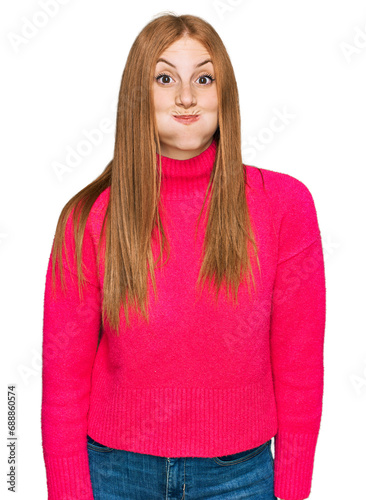 Young irish woman wearing casual clothes puffing cheeks with funny face. mouth inflated with air, crazy expression. © Krakenimages.com