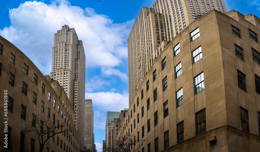 Fototapeta premium New York City skyline, skyscrapers, buildings with white clouds on the blue sky backgrounds, wide low angle diminishing perspective view