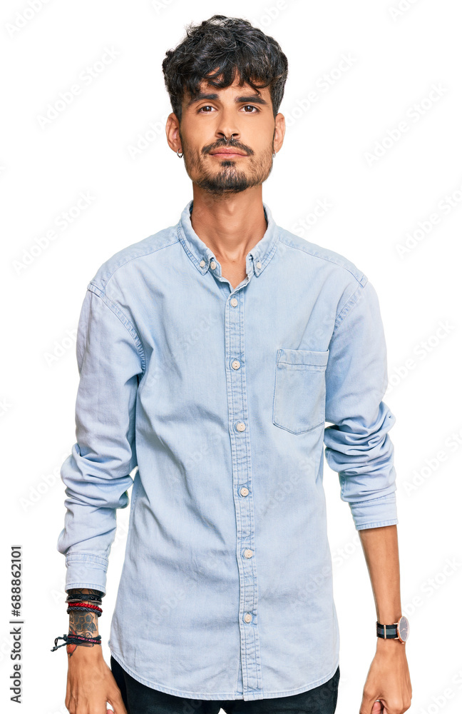 Fototapeta premium Young hispanic man wearing casual clothes looking sleepy and tired, exhausted for fatigue and hangover, lazy eyes in the morning.
