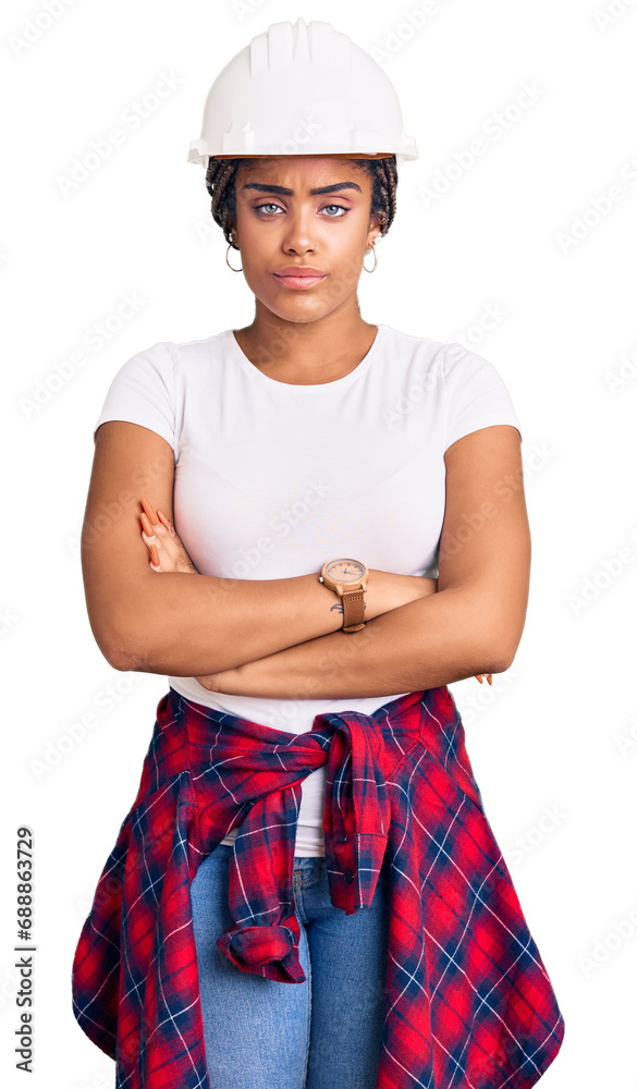Young african american woman with braids wearing hardhat and builder clothes skeptic and nervous, disapproving expression on face with crossed arms. negative person. Young african american woman with braids wearing hardhat and builder clothes skeptic and nervous, disapproving expression on face with crossed arms. negative person.