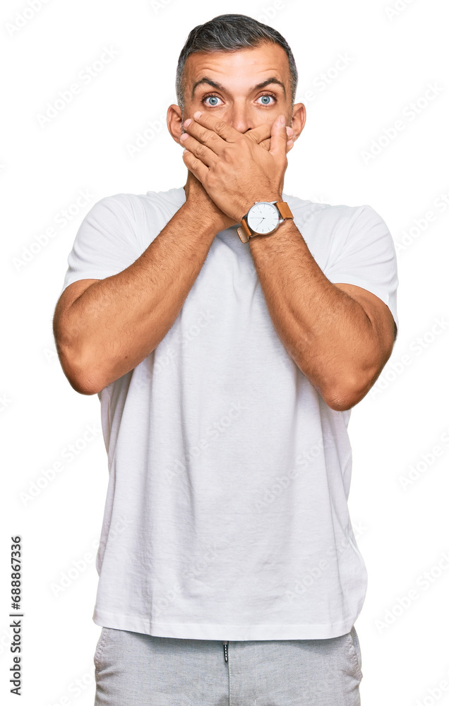 Middle age handsome man wearing casual white tshirt shocked covering mouth with hands for mistake. secret concept. Middle age handsome man wearing casual white tshirt shocked covering mouth with hands for mistake. secret concept.