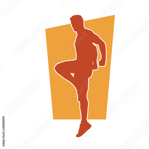 Silhouette of a sporty male in action pose at the gym. Silhouette of a slim man in aerobics workout pose.