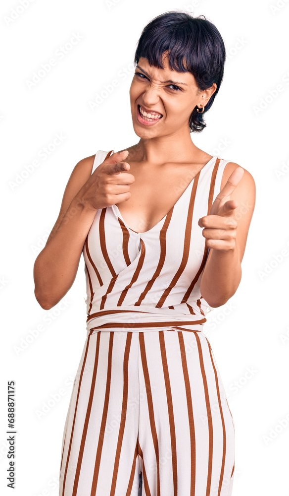 Young brunette woman with short hair wearing summer outfit pointing fingers to camera with happy and funny face. good energy and vibes. Young brunette woman with short hair wearing summer outfit pointing fingers to camera with happy and funny face. good energy and vibes.