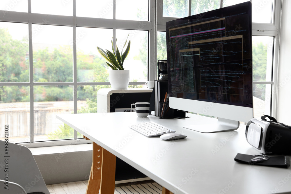 Fototapeta premium Computer monitor with programming code at workplace in office