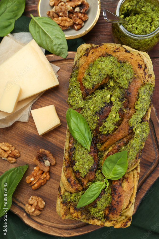 Freshly baked pesto bread with basil and cheese on table, flat lay Freshly baked pesto bread with basil and cheese on table, flat lay