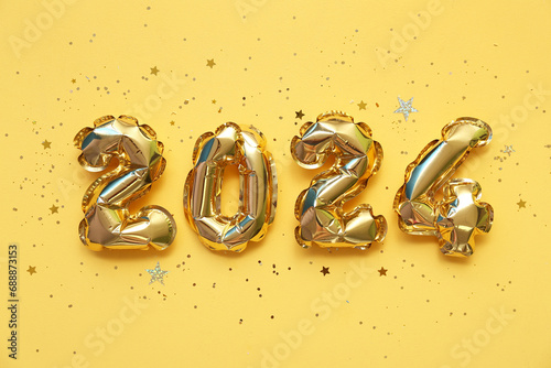 Figure 2024 made of balloons and confetti for Christmas celebration on beige background