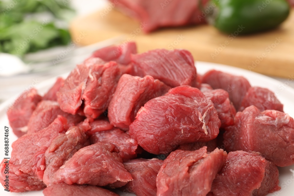Plate with pieces of raw beef meat on table, closeup Plate with pieces of raw beef meat on table, closeup