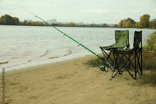 Folding chairs and fishing rod at riverside