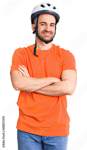 Young handsome man wearing bike helmet happy face smiling with crossed arms looking at the camera. positive person.