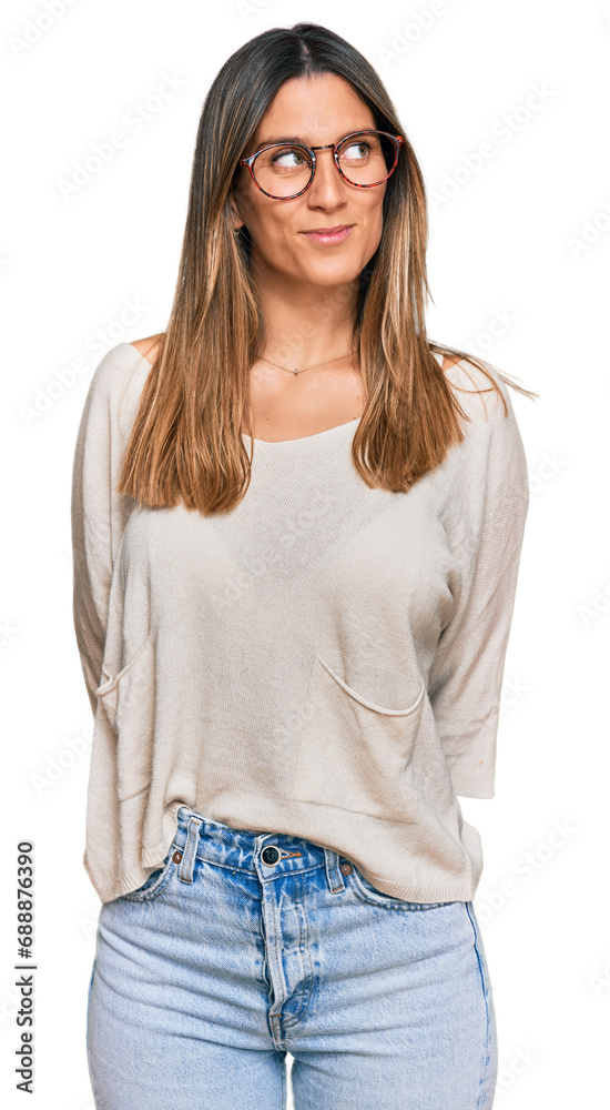 Young woman wearing casual clothes and glasses smiling looking to the side and staring away thinking. Young woman wearing casual clothes and glasses smiling looking to the side and staring away thinking.