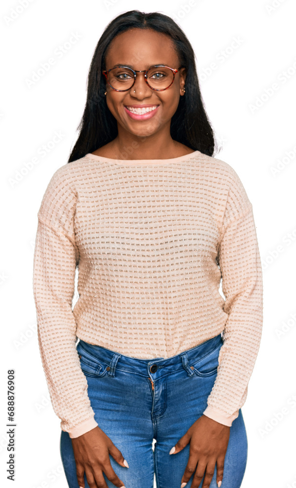 Young black woman wearing casual clothes and glasses looking positive and happy standing and smiling with a confident smile showing teeth Young black woman wearing casual clothes and glasses looking positive and happy standing and smiling with a confident smile showing teeth