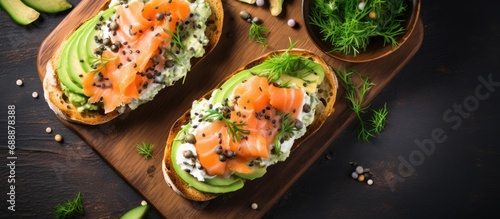 Top view of avocado and salmon toasts made with sourdough bread, cream cheese, and seeds.