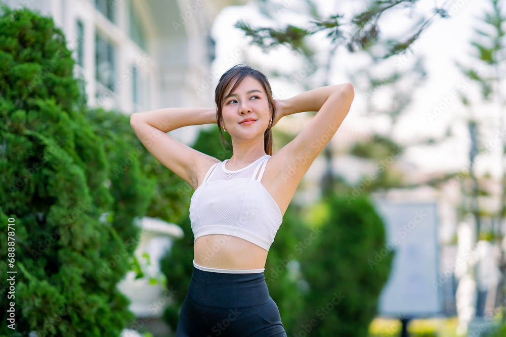 Happy slim woman wearing sportswear jogging and stretch the muscles to warm up the body in the city at sunrise. Young beautiful asian female in sports bra running outdoor.Healthy and active lifestyle Happy slim woman wearing sportswear jogging and stretch the muscles to warm up the body in the city at sunrise. Young beautiful asian female in sports bra running outdoor.Healthy and active lifestyle