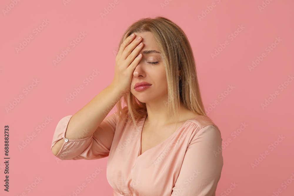 Young woman doing facepalm on pink background