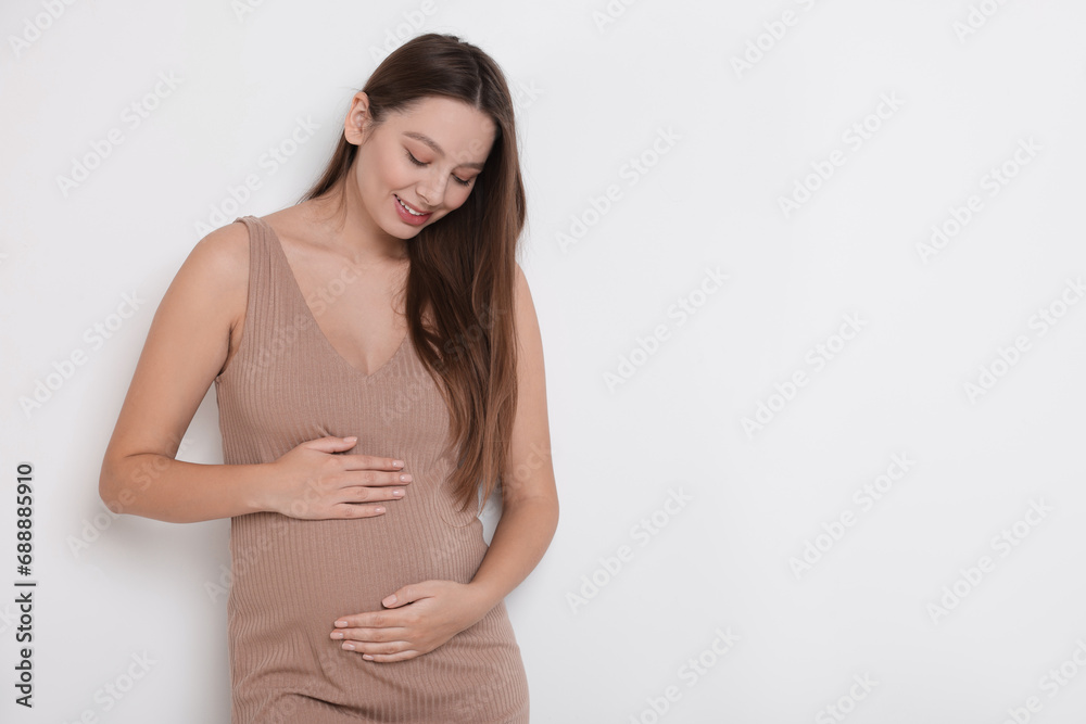 Beautiful pregnant woman in beige dress on white background, space for text Beautiful pregnant woman in beige dress on white background, space for text