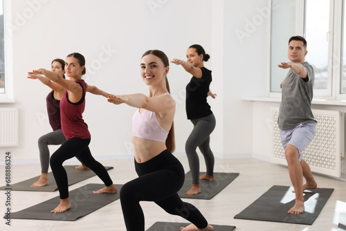 Fototapeta Naklejka Na Ścianę i Meble -  Group of people practicing yoga on mats indoors