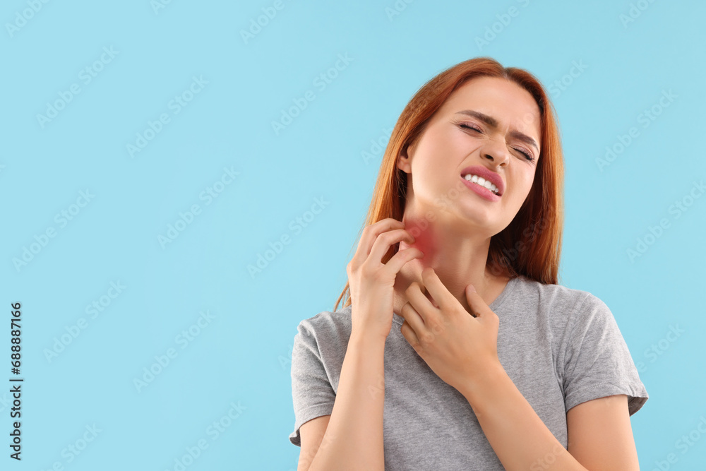 Suffering from allergy. Young woman scratching her neck on light blue background, space for text Suffering from allergy. Young woman scratching her neck on light blue background, space for text