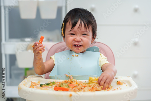 Fotografía happy infant baby eating food and vegetable by self feeding BLW or baby led wean