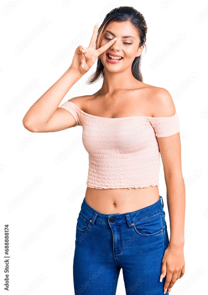 Young beautiful woman wearing casual clothes doing peace symbol with fingers over face, smiling cheerful showing victory Young beautiful woman wearing casual clothes doing peace symbol with fingers over face, smiling cheerful showing victory