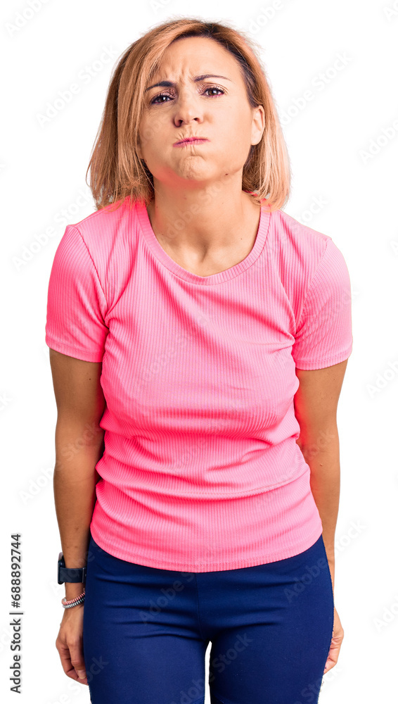 Fototapeta premium Young blonde woman wearing sportswear puffing cheeks with funny face. mouth inflated with air, crazy expression.