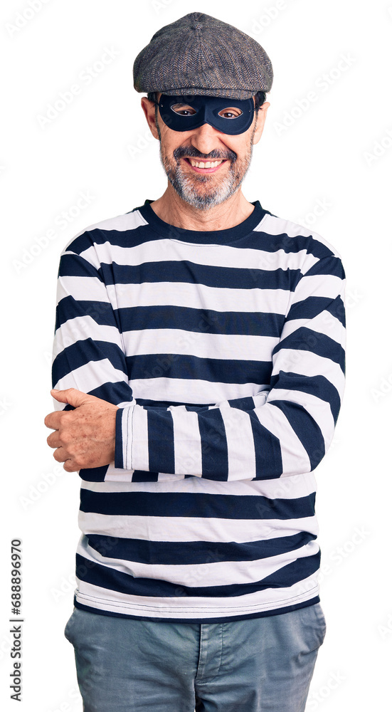 Middle age handsome man wearing burglar mask happy face smiling with crossed arms looking at the camera. positive person. Middle age handsome man wearing burglar mask happy face smiling with crossed arms looking at the camera. positive person.