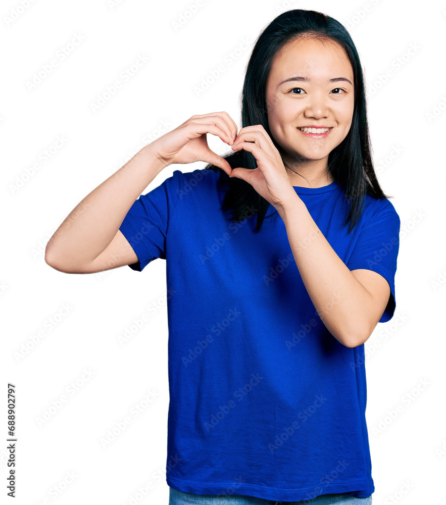 Young chinese woman wearing casual blue t shirt smiling in love doing heart symbol shape with hands. romantic concept. Young chinese woman wearing casual blue t shirt smiling in love doing heart symbol shape with hands. romantic concept.