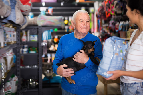Woman helping an elderly man buy dry dog food photo