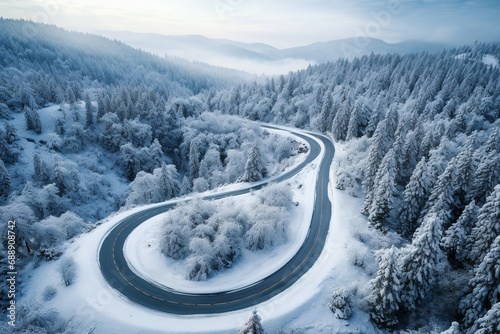 Top view of curved road with snow covering on trees in winter season