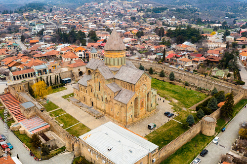 Aerial view of ancient Orthodox Svetitskhoveli Cathedral surrounded by defensive wall in historic Georgian town of Mtskheta on spring day