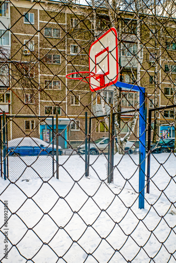 An empty snow-covered basketball court on a winter day An empty snow-covered basketball court on a winter day
