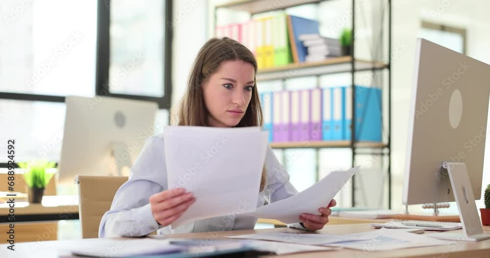 Woman worker compares documents after learning about mistake Woman worker compares documents after learning about mistake