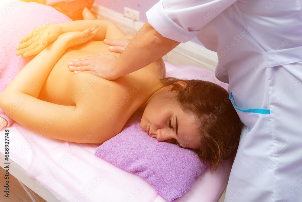 Blonde massage therapist massaging a woman. Woman getting a massage at the spa Blonde massage therapist massaging a woman. Woman getting a massage at the spa