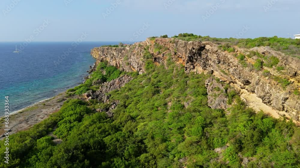 Drone rises above rocky Caribbean cliff to reveal Caracasbaai and Jan Thiel in Vista Royal, Curacao Drone rises above rocky Caribbean cliff to reveal Caracasbaai and Jan Thiel in Vista Royal, Curacao
