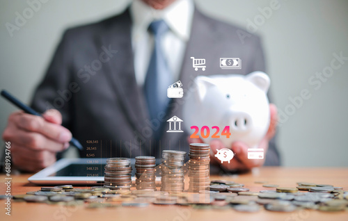 Businessman holding a piggy bank on a wooden table Save money and finance concept, business, finance, investment, financial planning Saving money in 2024.