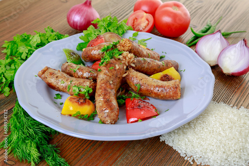 Grilled mumbar or sausage grill with onion, tomato and coriander served in dish isolated on table side view of arabic food photo